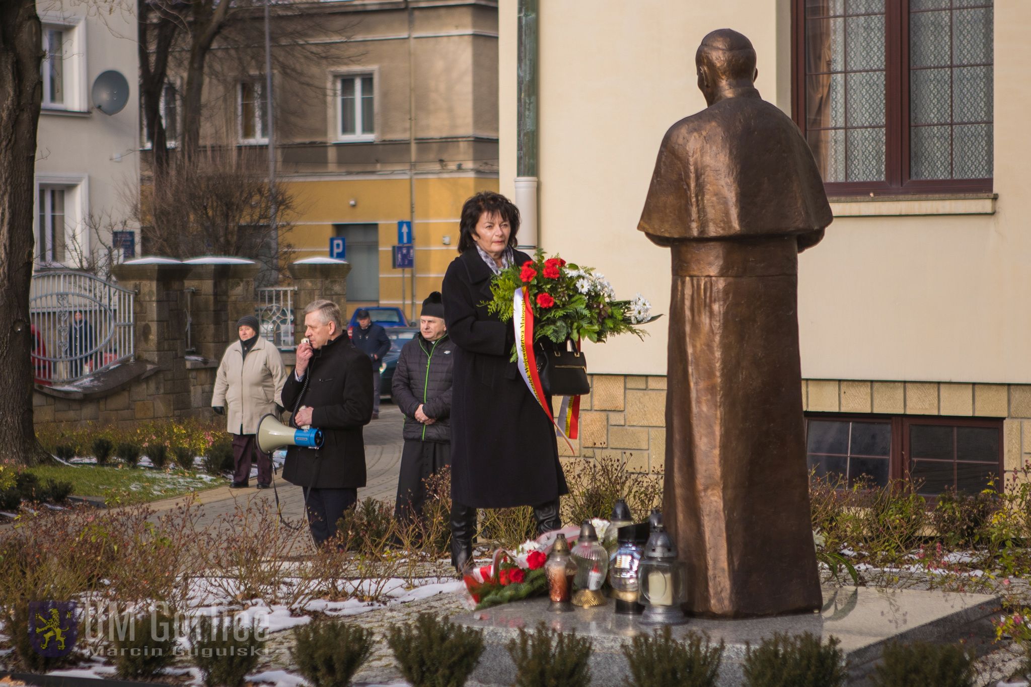 Radna jadwiga Wójtowicz składa wiązankę kwiatów.