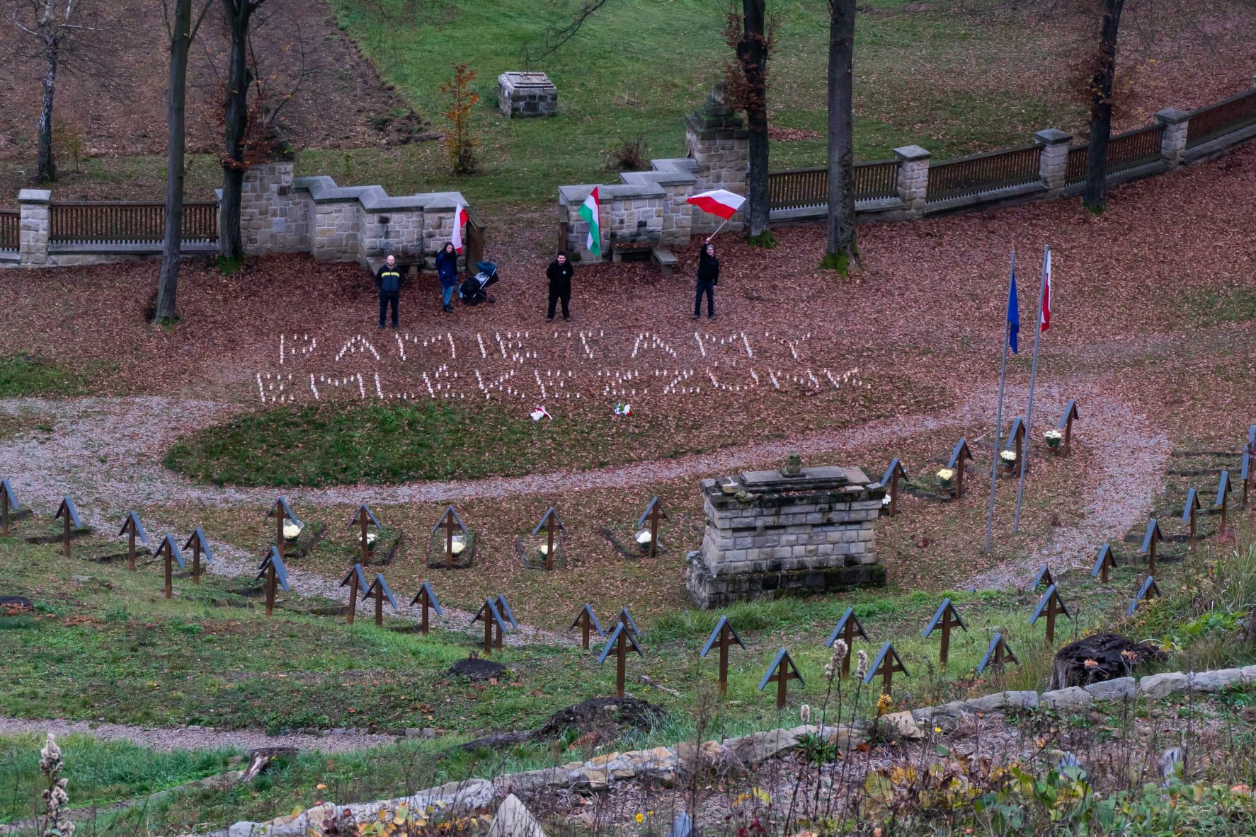 Członkowien organizacji Narodowe Gorlice na Cmentarzu w Łużnej, z napisem "Pamiętamy" ułożonym ze zniczy 