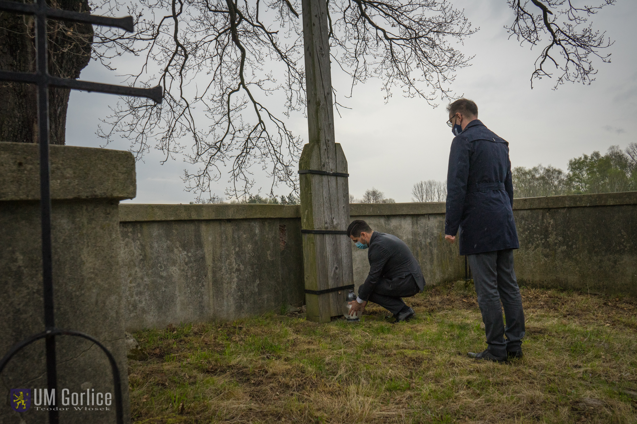 Wiceburmistrz i sekretarz zapalają znicz na cmentarzu wojennym