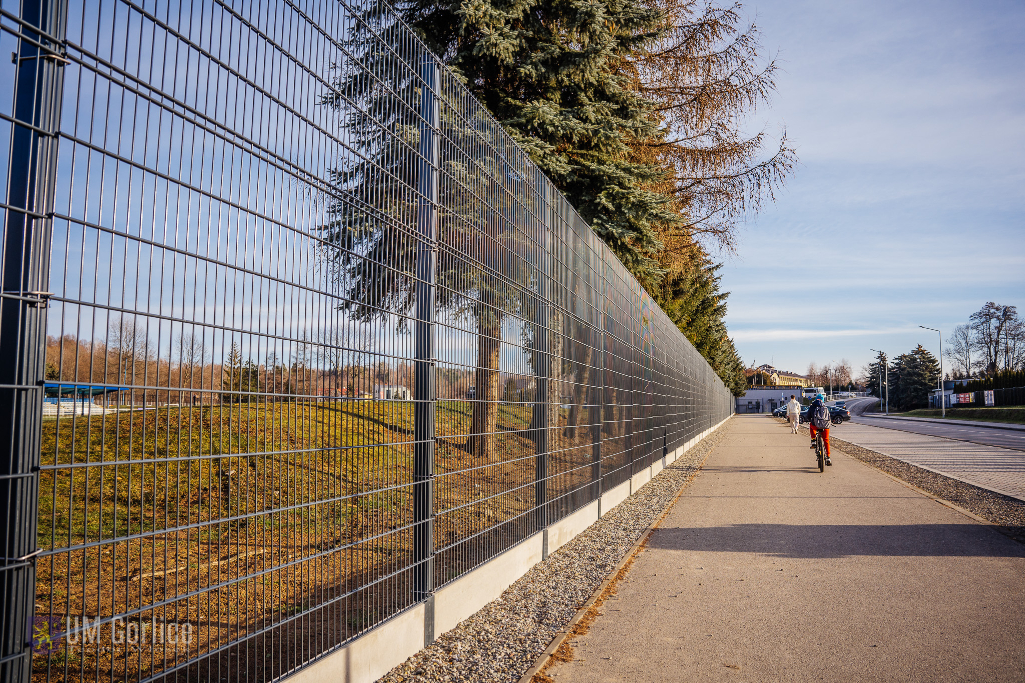 ogrodzenie stadionu przy ścieżce rowerowej