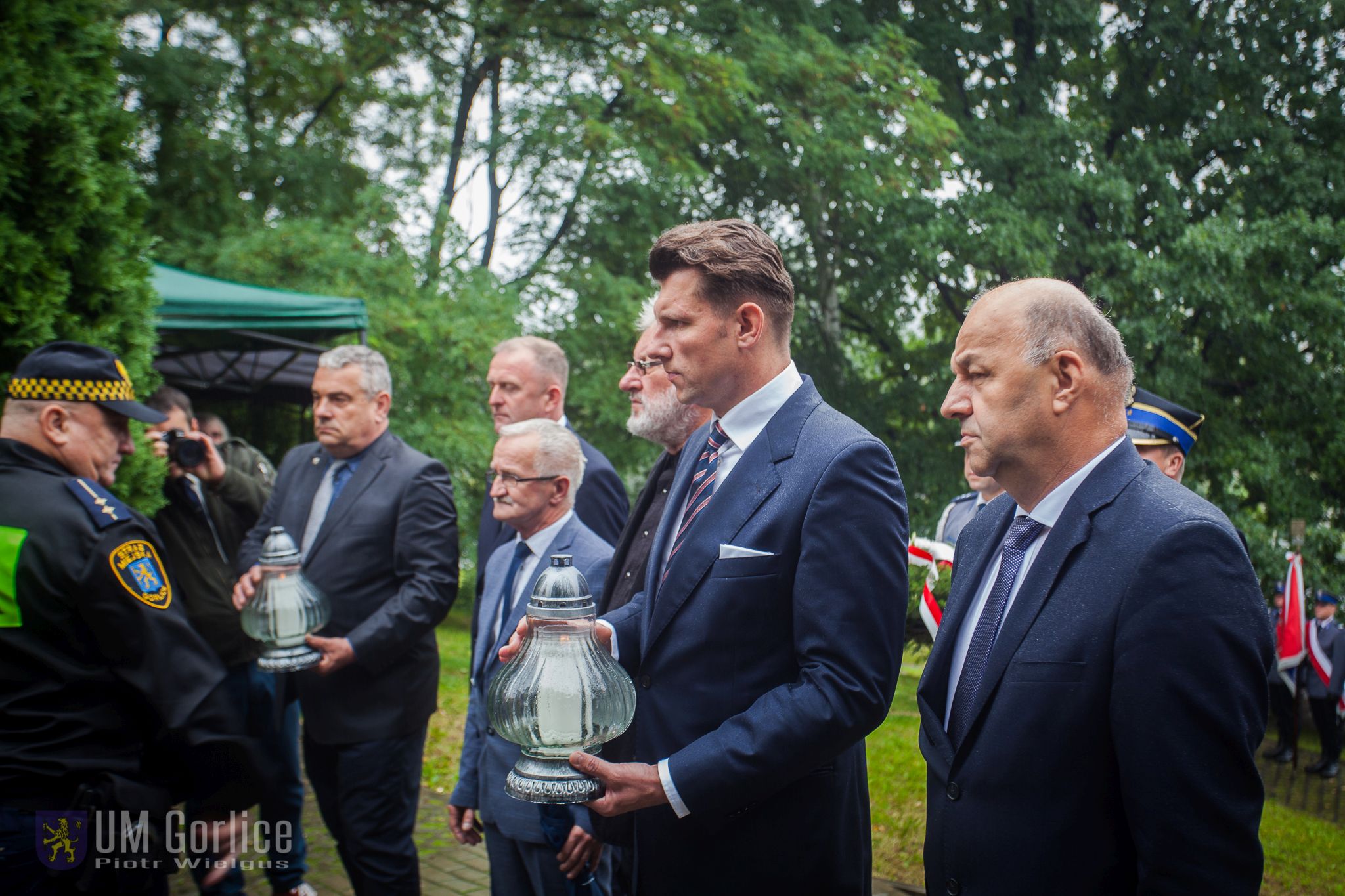 Samorządowcy składają znicz przed pomnikiem.