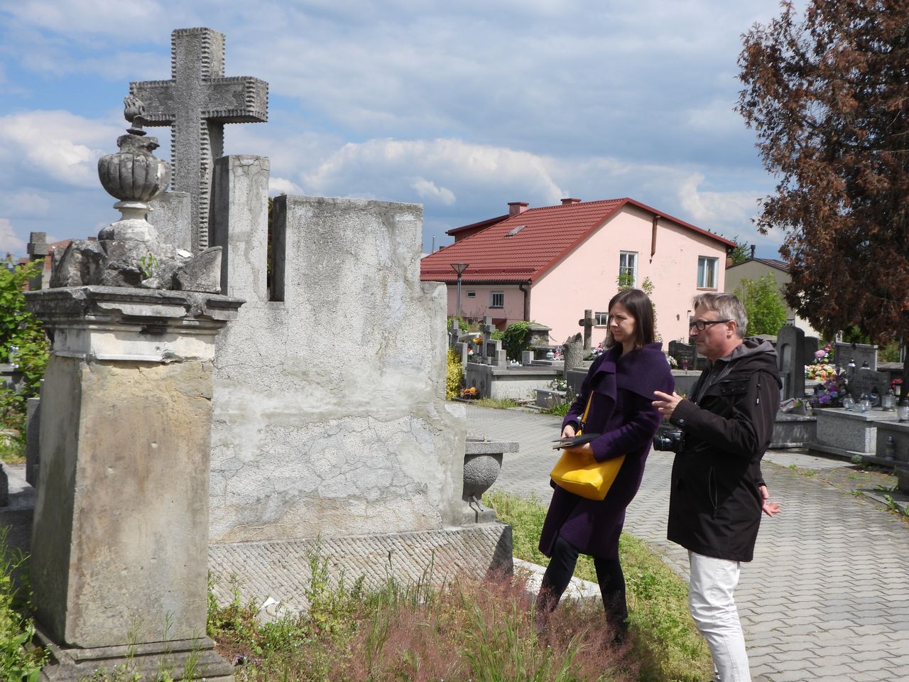 Nagrobek do renowacji - obok niego stoi kobieta i mężczyzna