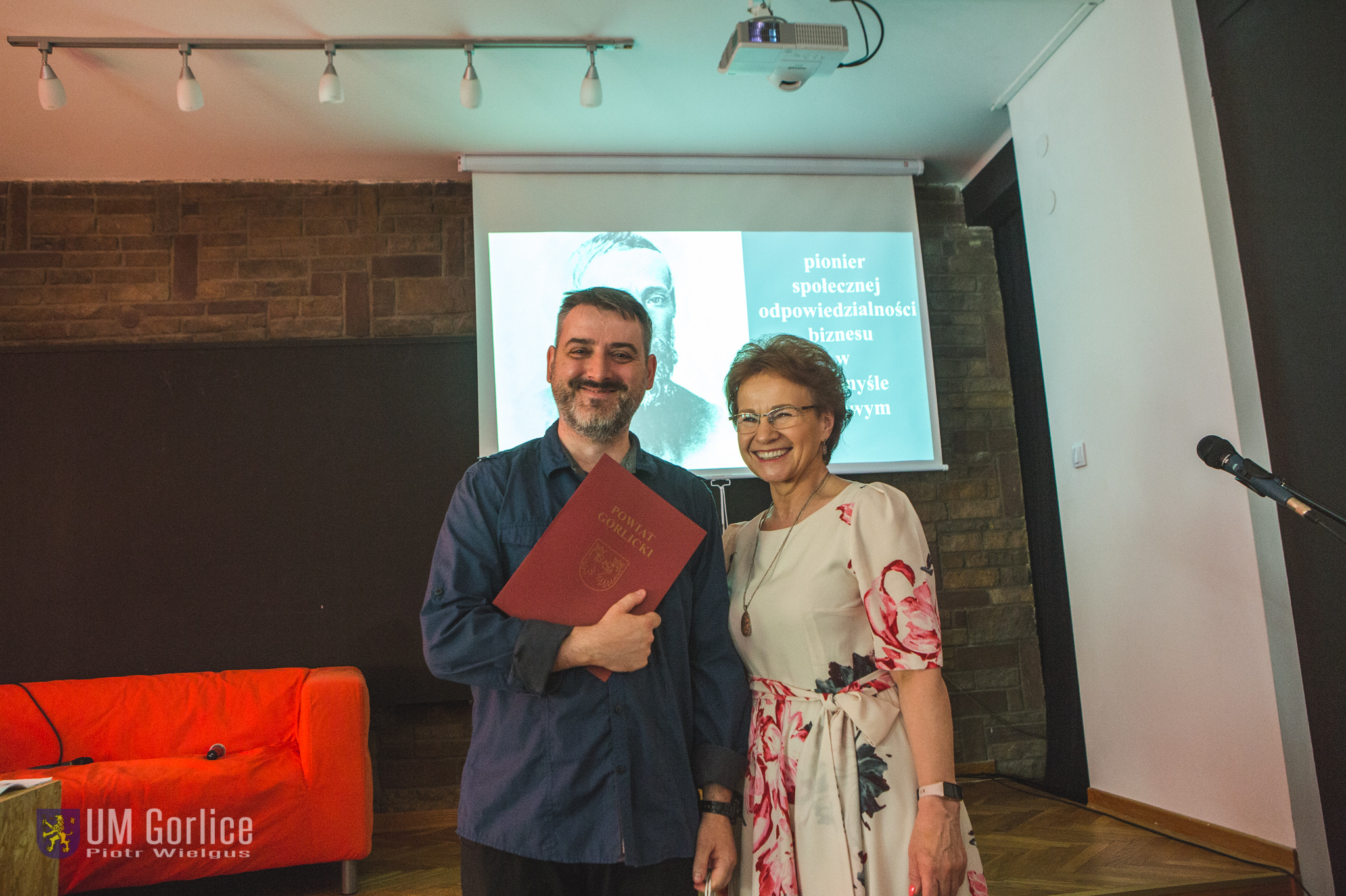 Bibliotekarze odbierają nagrodę z rąk starosty.