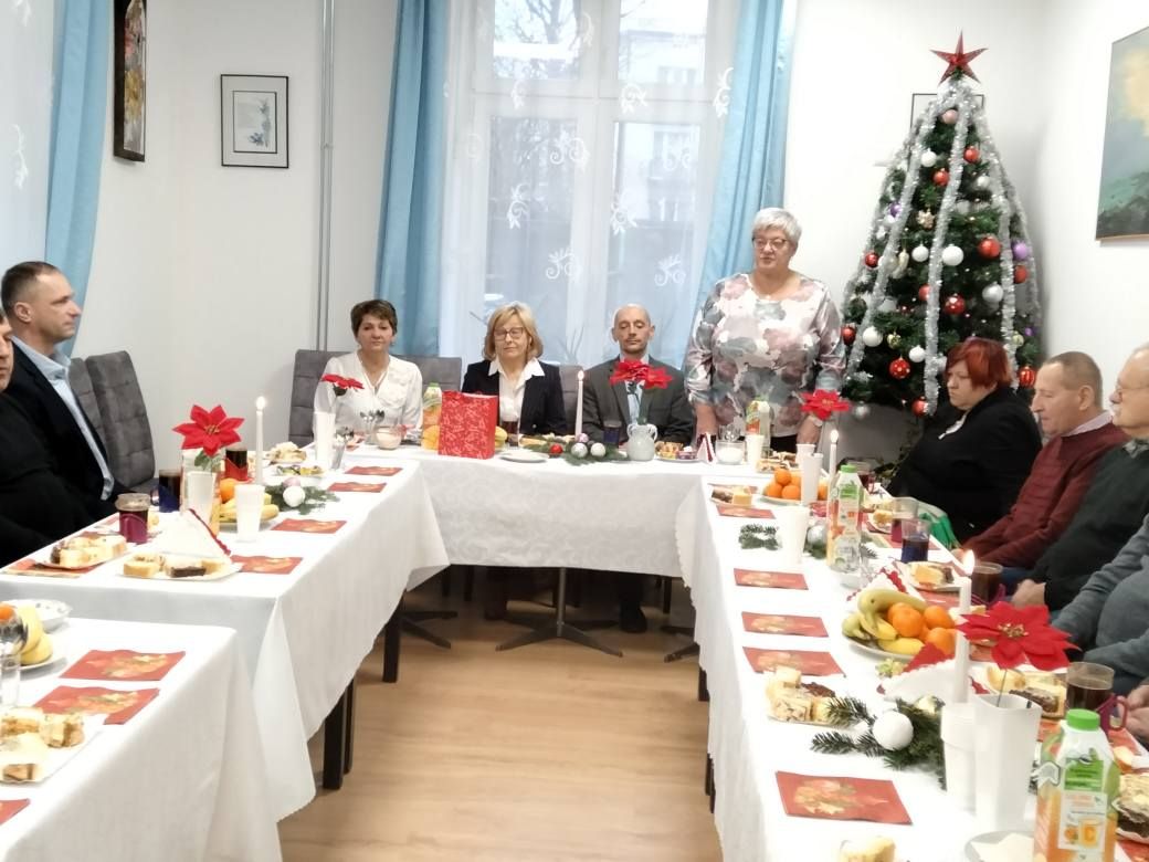 Goście podczas spokania wigilijnego siedzą przy stole.