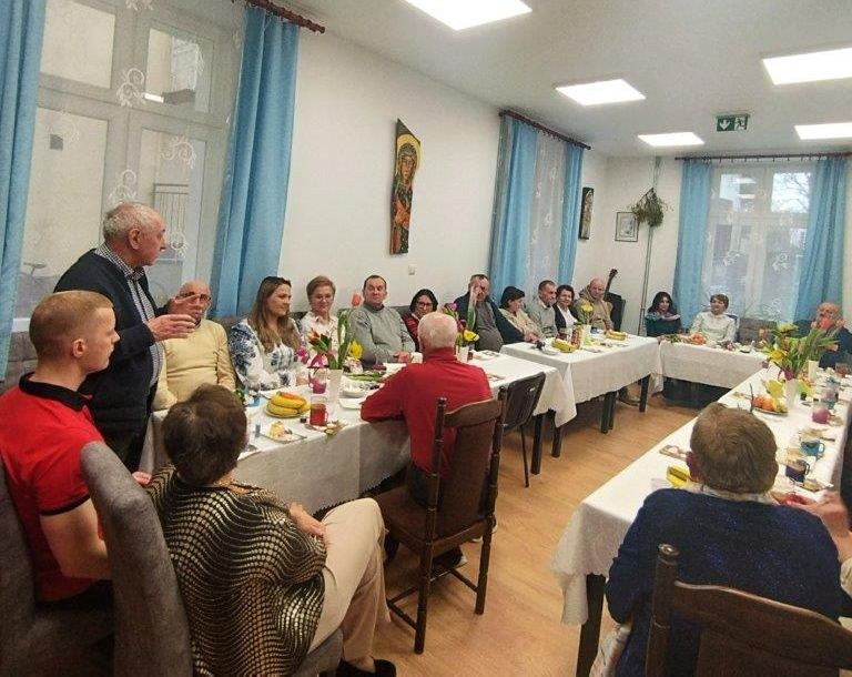 Dzień kobiet w Klubie Egida - uczestnicy siedzą przy stołach.