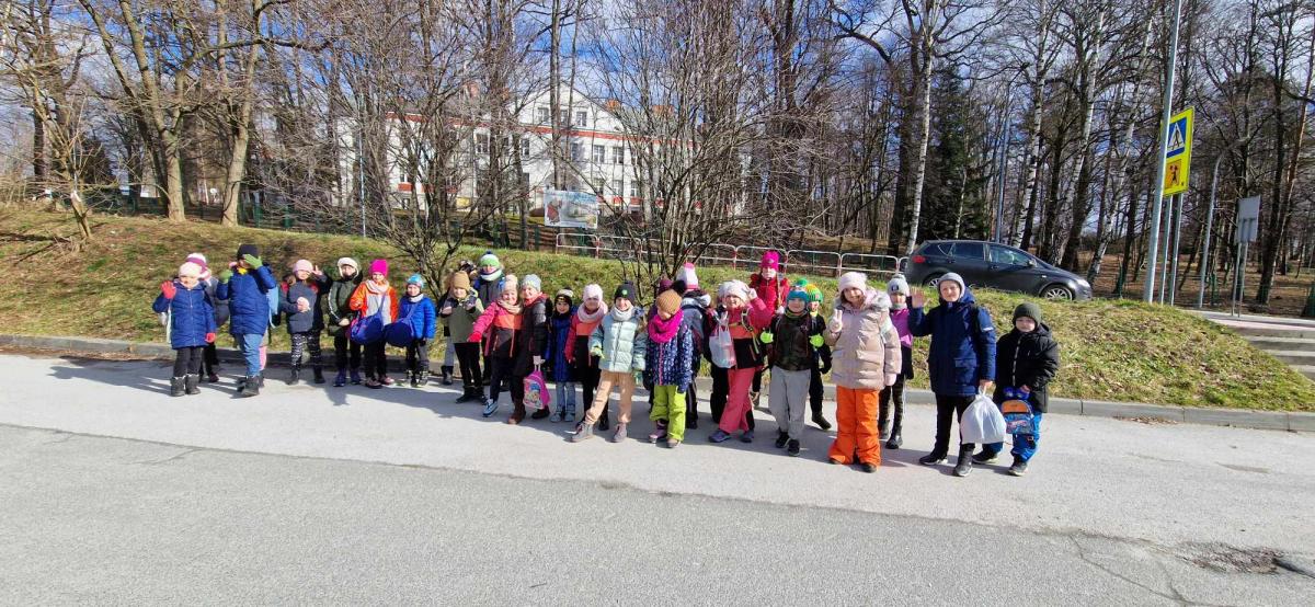 Dzieci stoją na drodze przed szkołą.