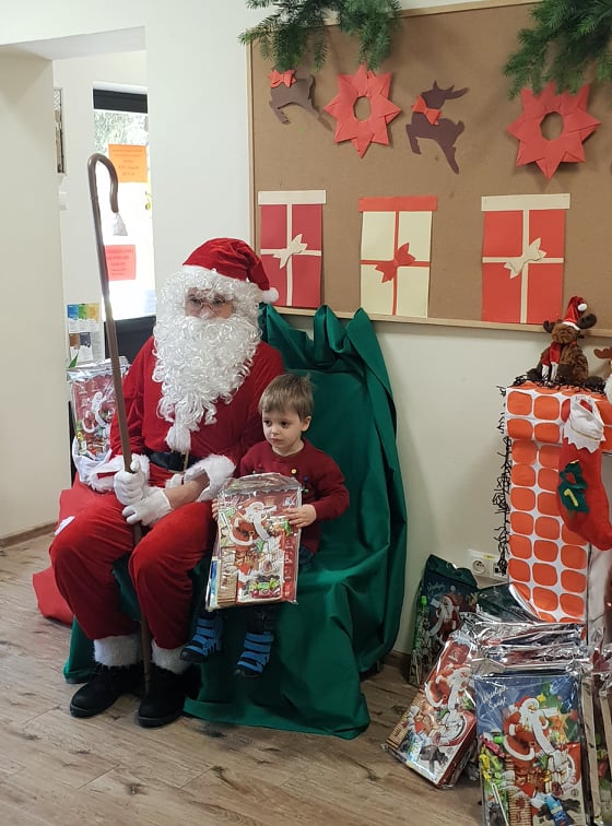 Zdjęcie dziecka z Mikołajem i prezentami