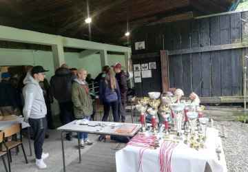 Uczestnicy zawodów i puchary na stole.