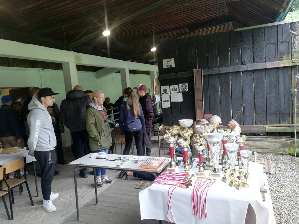 Uczestnicy zawodów i puchary na stole.