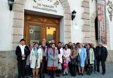 Członkowie klubu EGIDA stoją przed budynkiem teatru.