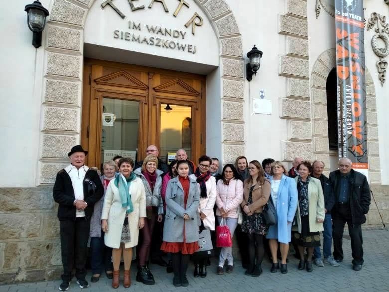 Członkowie klubu EGIDA stoją przed budynkiem teatru.