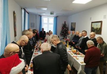 Członkowie klubu EGIDA stoją przy stołach.