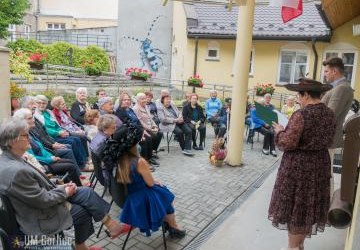 Uczestnicy narodowego czytania przed dziennym domem seniora.