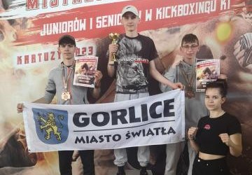 Zawodnicy klubu na podium z flagą Gorlice Miasto Światła.