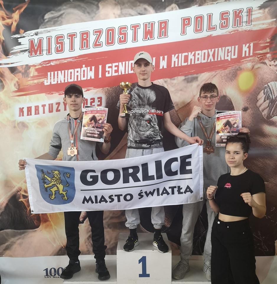 Zawodnicy klubu na podium z flagą Gorlice Miasto Światła.