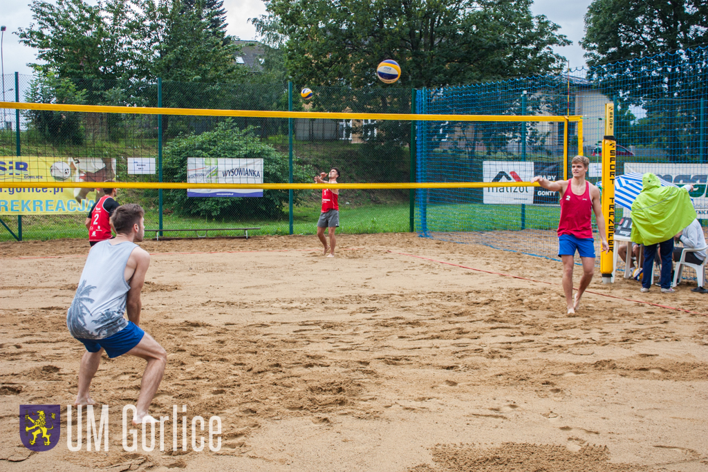Zawodnicy grają w siatkówkę plażową.