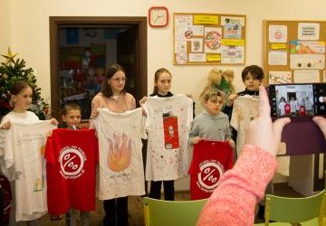 Dzieci prezentują koszuli z hasłami kampanii.