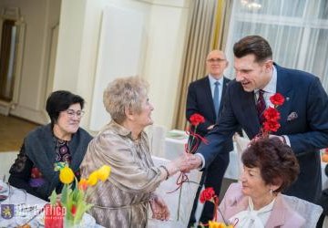 Burmistrz wręcza kwiaty.