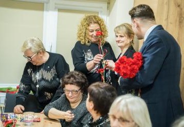 Burmistrz wręcza kwiaty.