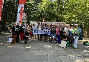 Grupowe zdjęcie seniorów z flagą Miasta Światła.
