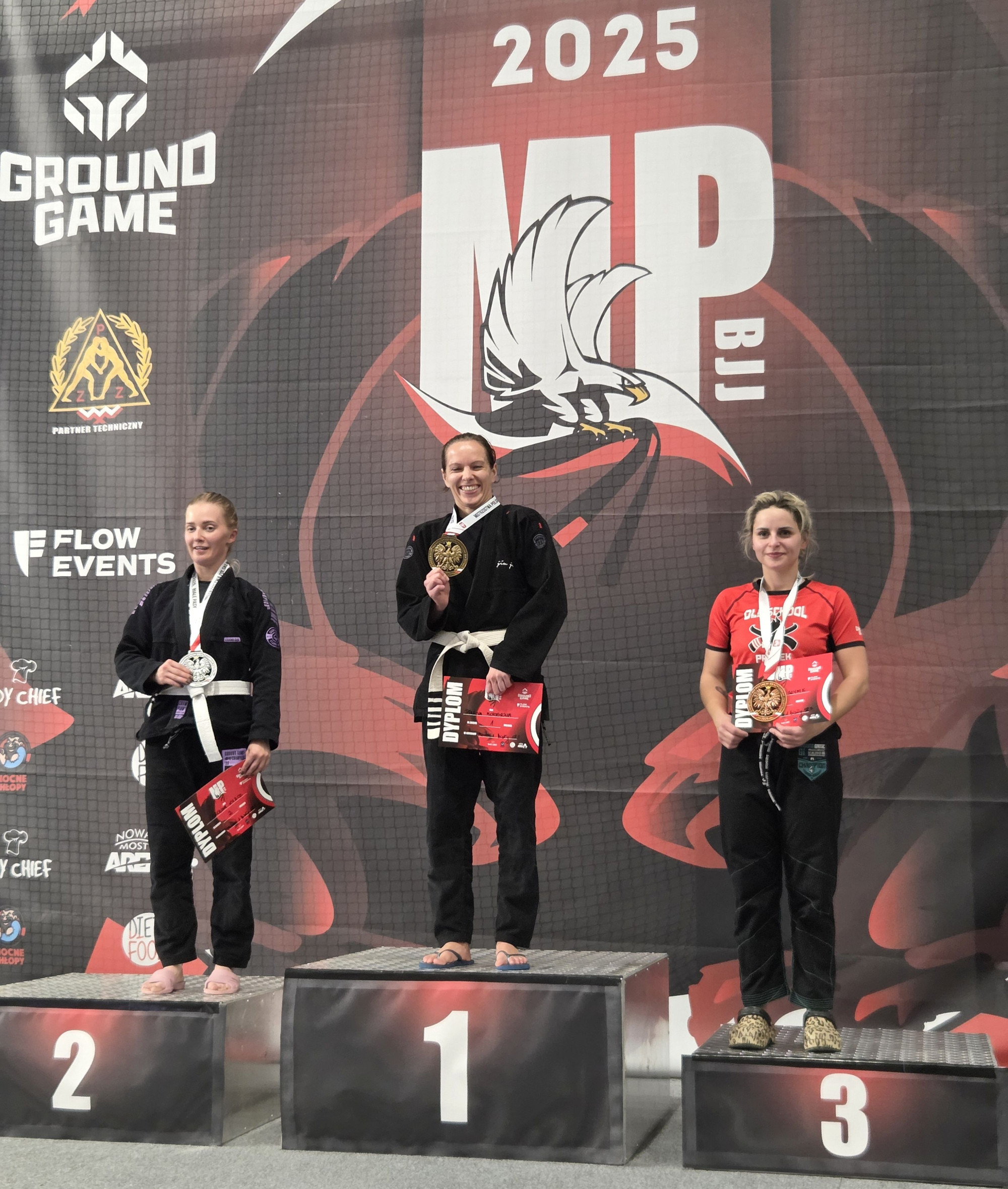 Trzy zawodniczki na podium z medalami.