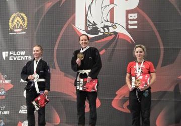 Trzy zawodniczki na podium z medalami.