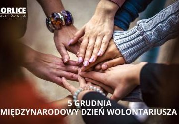 Ręce w okręgu, na pierwszym planie logo Gorlic i napis Miedzynarodowy Dzień Wolontariusza.