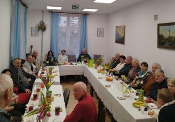 Dzień kobiet w Klubie Egida - uczestnicy siedzą przy stołach.