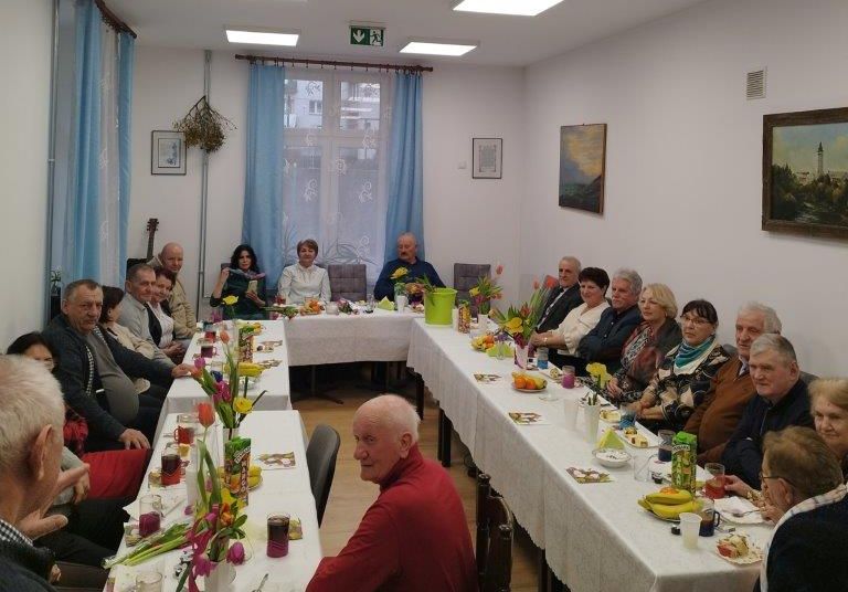 Dzień kobiet w Klubie Egida - uczestnicy siedzą przy stołach.