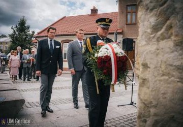 Burmistrz składa wiązankę kwiatów.