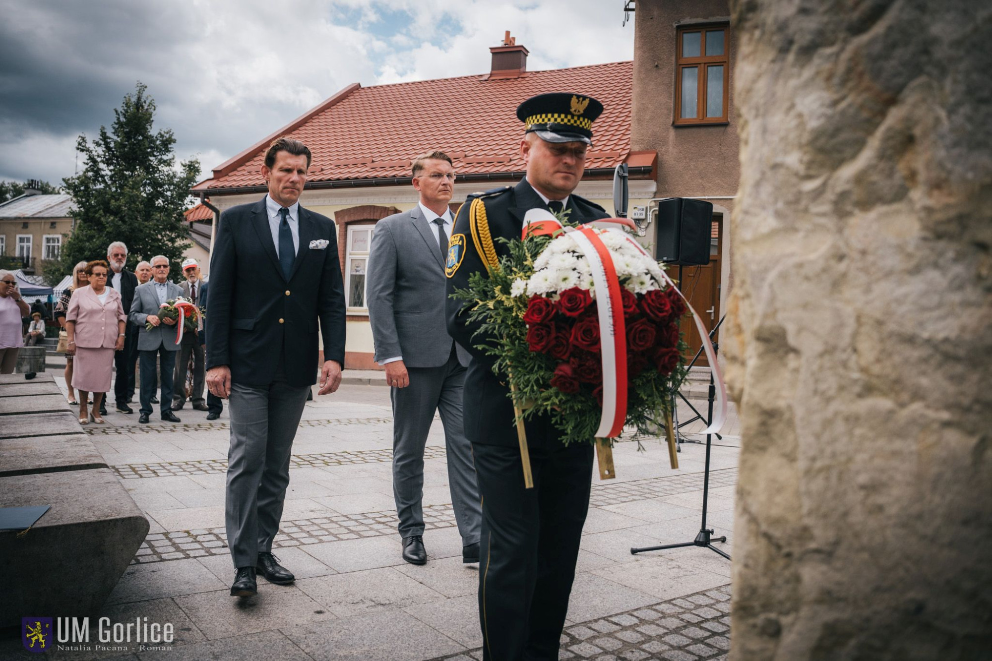 Burmistrz składa wiązankę kwiatów.