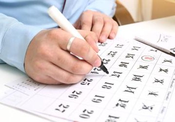 Ręka pisząca na kelendarzu.